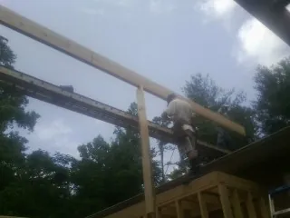 Carpenter setting a ridge beam over a new addition frame — Ice Dam Removal by Roofing Brothers in Seaview